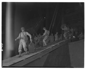[Negative of Soliders Hauling Packs of a Ship at Night]