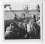 Photograph: [Men Pushing a Jeep on Board a Boat]