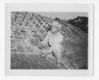 Photograph: [Serviceman Working on Hut Roof]