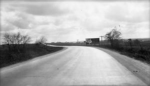 Primary view of object titled '[Photograph of a Billboard Near Unknown Road]'.