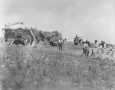 Photograph: [The harvesting of rice. Rice farming machinery to the left.]