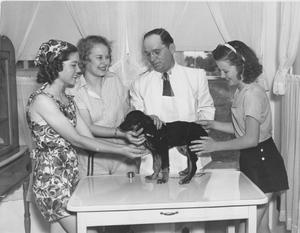 Dr. Crabb Vaccinates a Dog While Three Ladies Observe