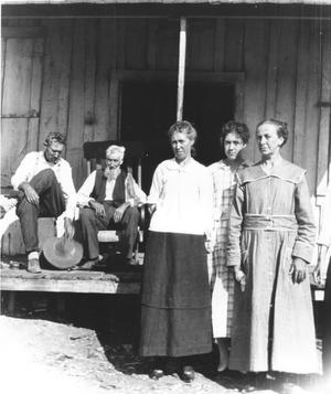 George W. Couch and Another Man Sitting on the Porch of Couch's Store and His Wife with Two Other Ladies Standing In Front of Them