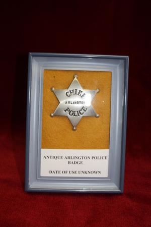 Primary view of object titled '[Image of antique APD Chief Badge, on red fabric]'.