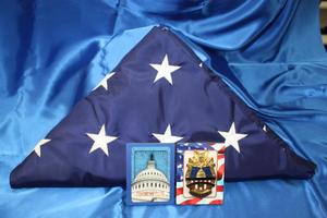 [Image of a United States Commemorative Capitol Police Badge and a triangular folded U.S. Flag]