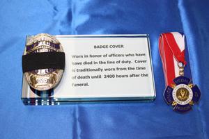 [Image of an APD badge with mourning cover and a police Medal Of Honor medalian]