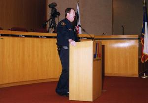 [Arlington Police Officer Dee Anderson speaking in city council chamber room]