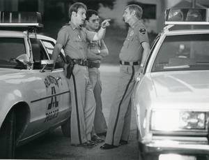 [Arlington Police Officers Tom LeNoir and Eddie Thompson speaking to Chaplain Harold Elliott]