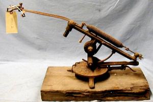 Primary view of object titled '[Metal device on wooden base used for throwing clay targets.]'.