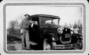 [Unidentified man standing next to an automobile, a Model A Ford]
