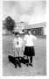 Photograph: [Two girls holding hands near downtown Rosenberg, TX]