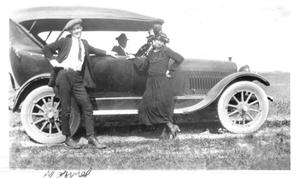 [Norveil Phillippi standing in front of automobile with woman]