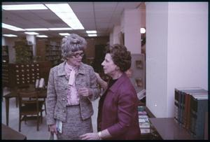 [Two Women in a Discussion in a Library]