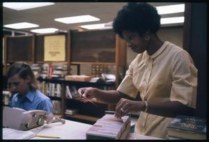 [Woman Selects a Card from the Card Catalog]