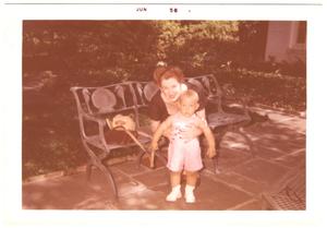 [Lillie Abercrombie with toddler on patio bench]