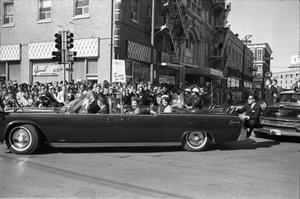 Primary view of object titled '[The presidential limousine turning onto main street in downtown Dallas]'.