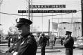 Thumbnail image of item number 1 in: '[Dallas Police officers standing guard outside the Dallas Trade Mart]'.