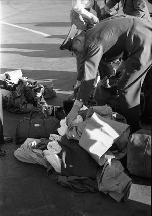 [A pile of searched luggage on the tarmac at Love Field]