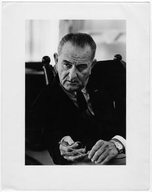 Primary view of object titled '[President Lyndon Baines Johnson seated holding glasses, front view]'.