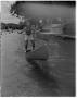 Photograph: [Man standing on canoe in Barton Springs Pool]