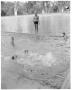 Primary view of [Man standing at edge of Deep Eddy pool while instructing swimmers in pool]