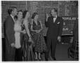 Photograph: [Men and women, including Zack Scott, standing in front of chalkboard]