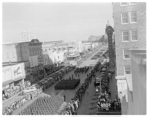 [Military groups marching in a parade held in front of the Capitol building]