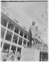 Photograph: [A statue of Governor J.S. Hogg next to a building under construction]
