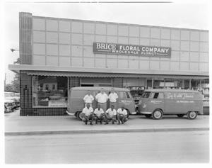 Primary view of object titled '[Men posing in front of vans with Brice Floral Company shop in the background]'.