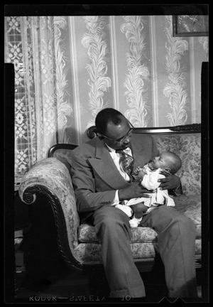 [Photograph of a Man Holding a Baby]