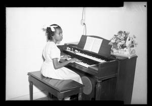 [Photograph of a Young Girl Playing a Piano]