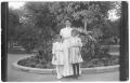 Photograph: [Woman and Two Girls Standing Outdoors]