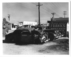Primary view of object titled '[Wrecked cars in front of "Frank's Wrecker Service"]'.
