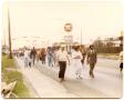 Photograph: [People Marching Past Gas Station]