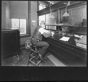 Primary view of object titled '[Southern Pine Lumber Company Office Worker at Accounts Desk]'.