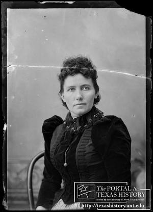 [Seated woman in a dark velvet dress with lace collar]