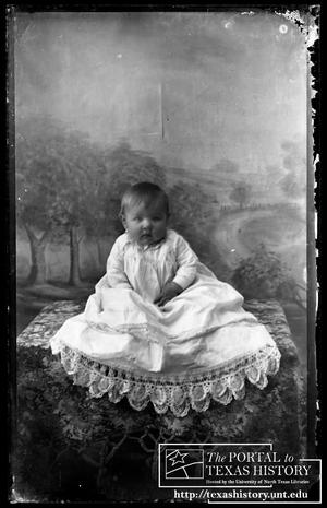 [Baby in an elaborate white gown]