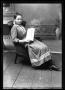 Photograph: [Girl sitting in a chair holding the "Youth's Companion" magazine]