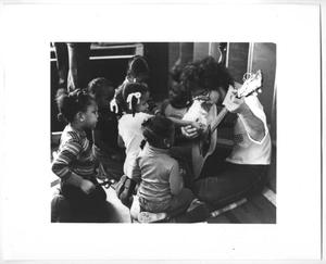 [Photograph of a Man Showing Children How to Play Guitar]