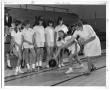 Primary view of [Photograph of Students Learning How to Bowl at a School Gym]