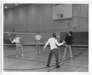 [Photograph of Students Playing Badminton in a School Gymnasium]