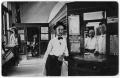 Postcard: [Young man standing in bank]