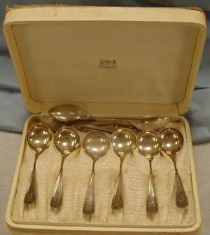 set of silver spoons in yellow case