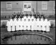 Photograph: [NTSU A Capella Choir poses behind a pond with a fountain]