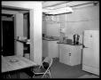 Photograph: [Room with sink, coffee, and refrigerator]