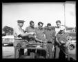 Photograph: [Men viewing machine parts in front of Denton police car]
