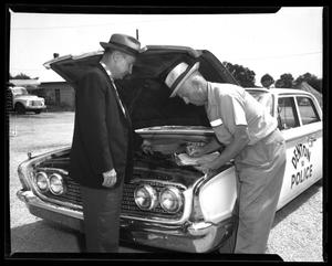 Primary view of object titled '[Andy Anderson and Pedro Parsons in front of a City of Denton police car]'.