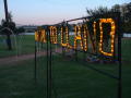 Primary view of ["Welcome to Llano" sign illuminated in evening sky]