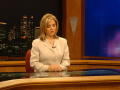 Photograph: [Claudia behind the newsdesk with her hands on the desk]