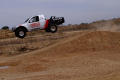 Primary view of [Truck going airborne after going over a dirt mound]